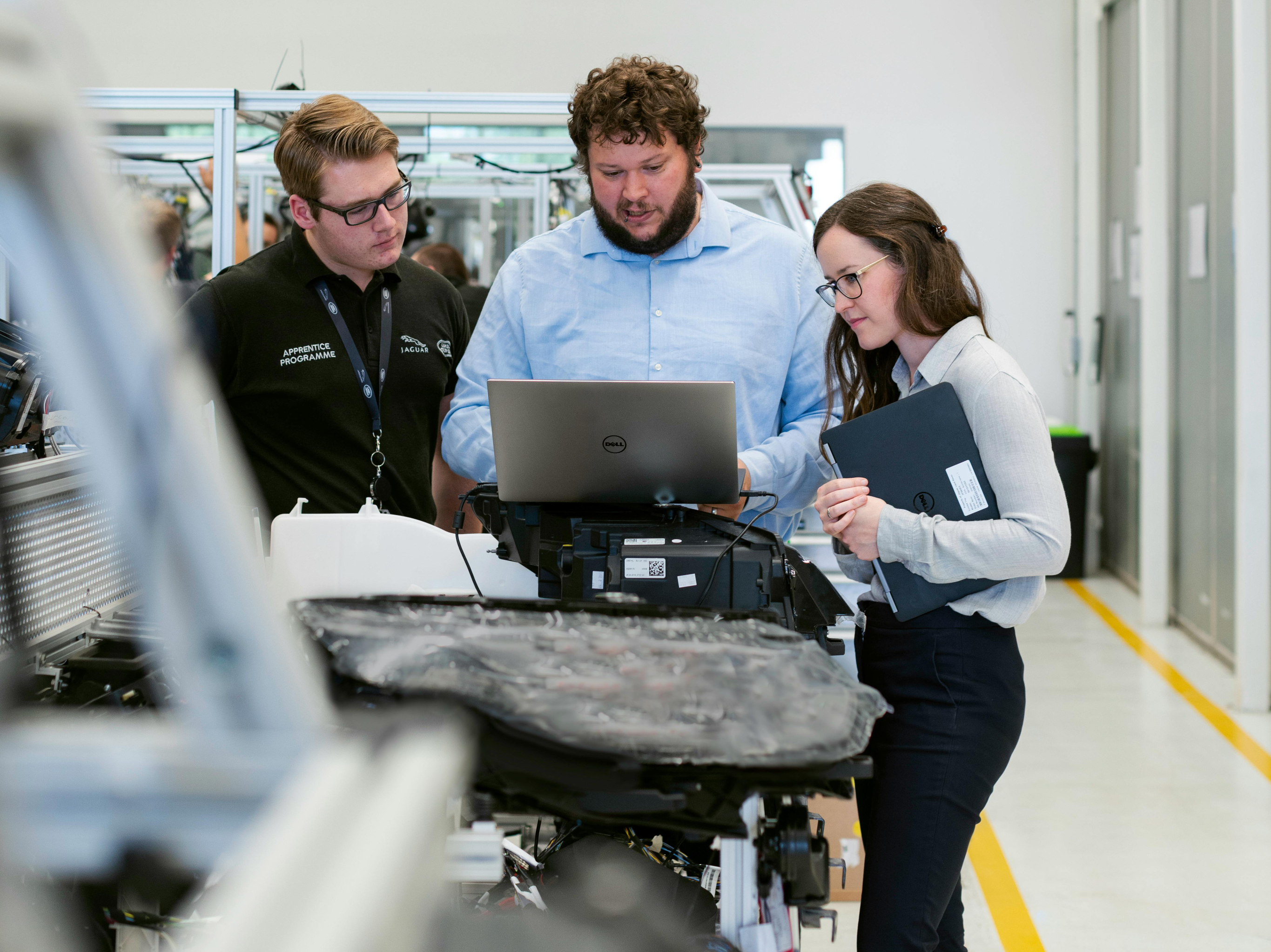 People looking at a laptop in a workshop